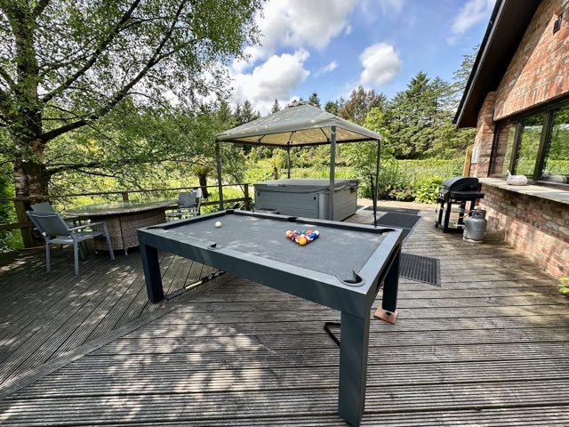 Luxury Lakeview Retreat: Decking with the pool table, covered hot tub and BBQ