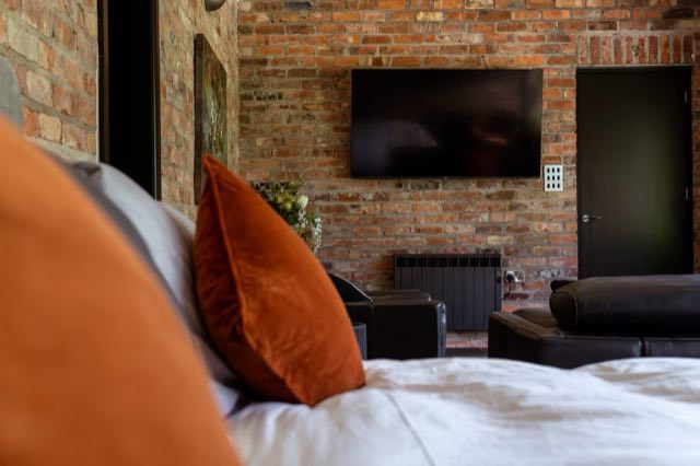 Luxury Lakeview Retreat: View from the bed to the TV on the brick wall