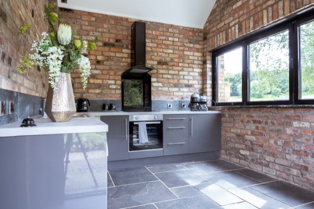 Luxury Lakeview Retreat: Kitchen with oven, hob and a window onto the garden