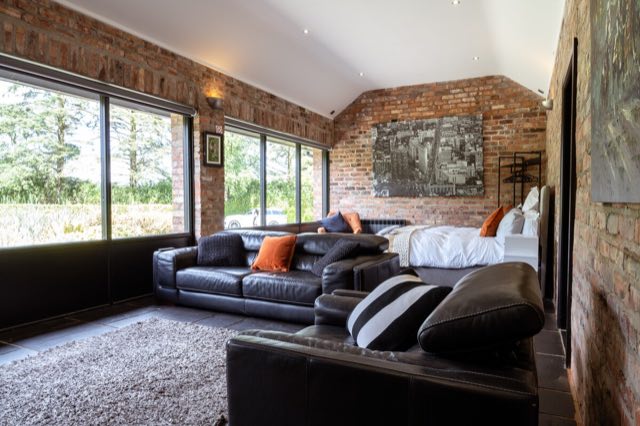 Luxury Lakeview Retreat: Living area with leather sofas and floor-to-ceiling windows
