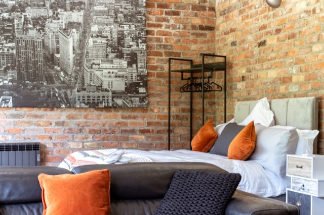 Luxury Lakeview Retreat: Super king bed below city artwork on the brick wall