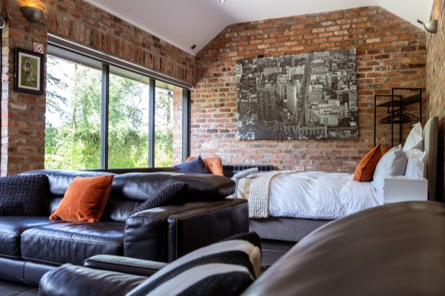Luxury Lakeview Retreat: Sofas and bed by the large garden windows