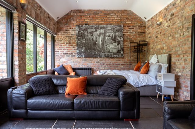 Luxury Lakeview Retreat: Leather sofa in front of the bed