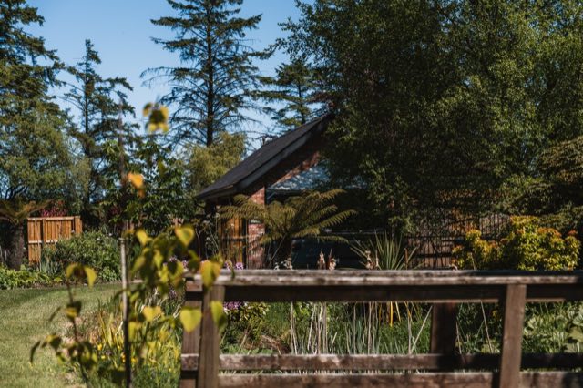 Luxury Lakeview Retreat: The lodge behind the garden fence and planting