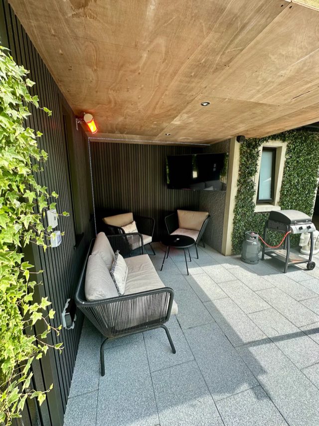 Luxury Studio: Covered outdoor lounge with sofa, chairs, TV and heater