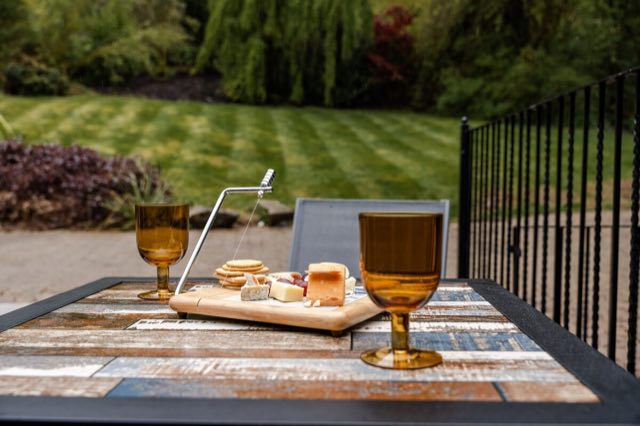 Luxury Studio: Drinks and a cheese board on the patio table, overlooking the lawn